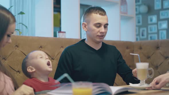 Professional Waiter Brings Glass of Coffee To Young Couple alt
