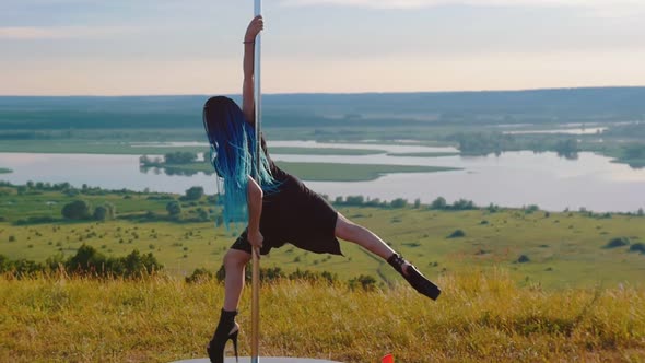 Pole Dance on Nature - Sexy Woman with Blue Braids in Black Clothes Spinning on the Pole Wearing alt