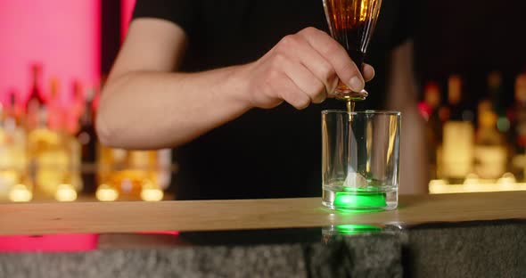 Bartender Drips Grenadine Syrup on Lump Sugar in Slow Motion Making the Cocktail on the Bar Counter
