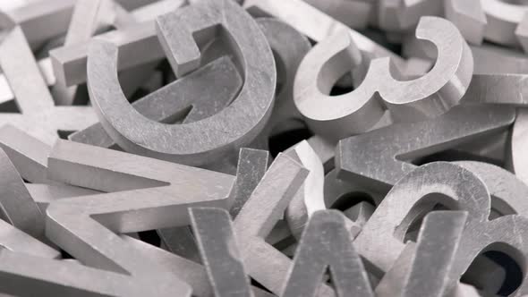 Full Frame Closeup Looped Rotating Background of Silver Metal Letters alt
