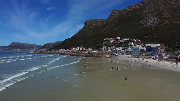 Side drone shot of surfers at Muizenberg beach, Cape Town - docents of surfers trying to catch a wav alt