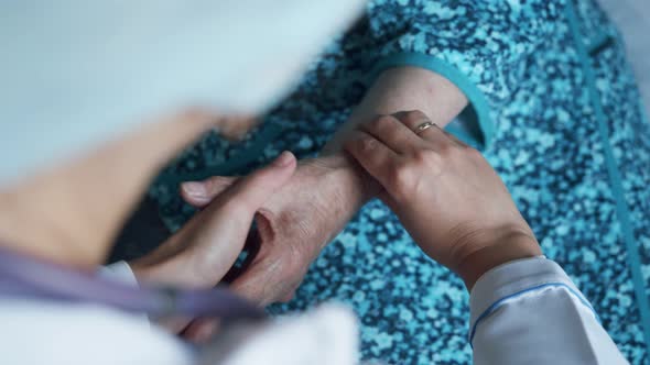 Closeup of Medic's Hands Checking Pulse in Elderly Woman Coronavirus Infection Test alt