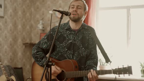 Man Playing Guitar and Singing During Rehearsal