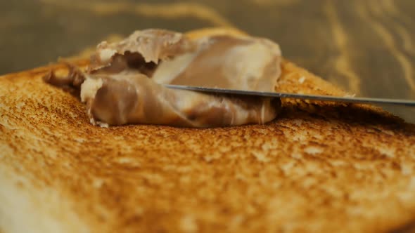 Carefully Smear the Chocolate Paste with a Knife on a Piece of Toasted Bread alt