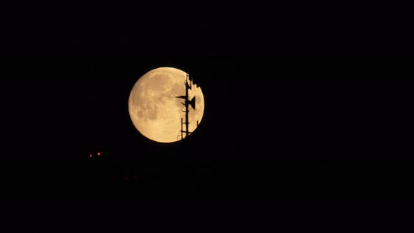 Time Lapse of Full Moon on Dark Night Sky Passing Against Antenna