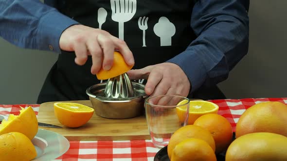 A Man Makes Freshly Squeezed Juice From Oranges and Grapefruit