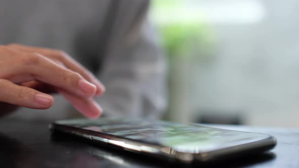 Closeup of a woman touching and scrolling on smart phone screen