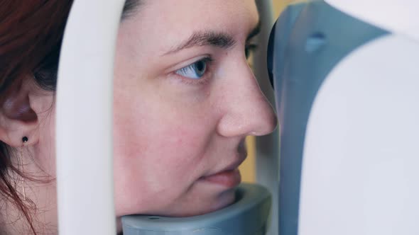 A Lady is Having Her Eyesight Checked By a Machine alt