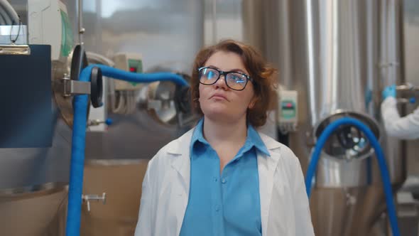 Portrait of Confident Female Scientist in Lab Coat Walking in Modern Beer Factory alt