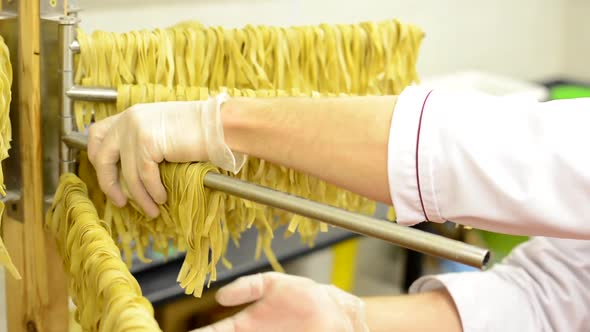 A Worker Takes Down Dried Pasta From Stand - Closeup alt