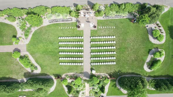 Drone shot coming down on a wedding ceremony setup in a courtyard garden alt