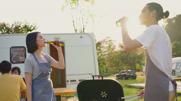 Group of Asian man and woman enjoy camping holiday party eating barbecue and drinking with happiness alt