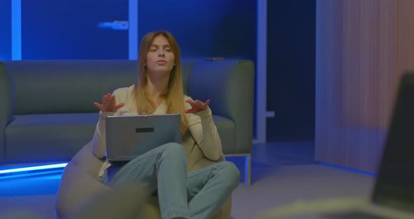 Beautiful Girl Sits in a Chair with a Laptop and Speaks Emotionally Talk Show