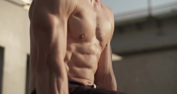 Muscular Sportsman Doing Gymnastic Exercise on Bars alt