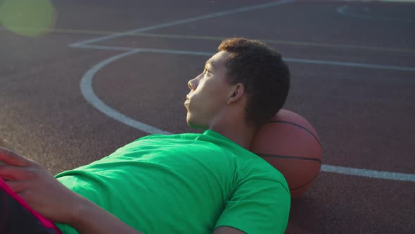Basketball Player with Phone Resting After Training alt