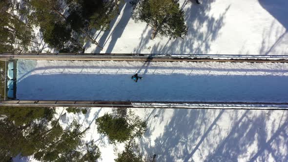 Man walking towards edge of Stegastein viewpoint seen from birdseye perspective - Cool top-down view alt