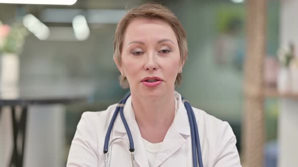 Friendly Middle Aged Female Doctor Talking on Video Call  alt