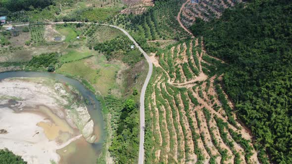 Aerial forward view over slope deforested next to river. Cam Ranh. Vietnam alt