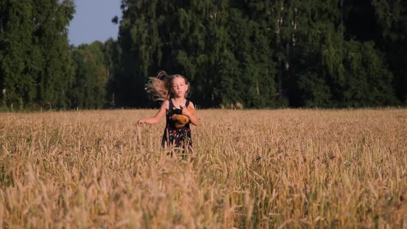 Cute Little Girl Running Through a Wheat Field alt