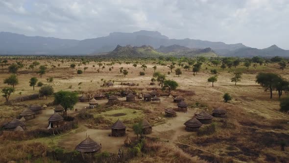 Aerial above an authentic Village With homes made from wood and straw in Uganda, East Africa alt