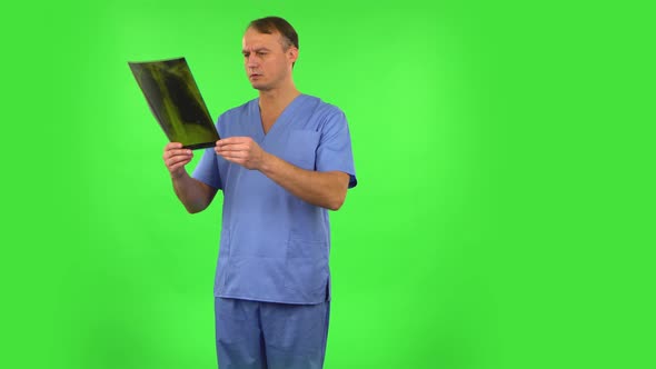 Male Doctor Reviewing X-ray Pointing on Snapshot, Explains and Shakes His Head Negatively Shrugs alt