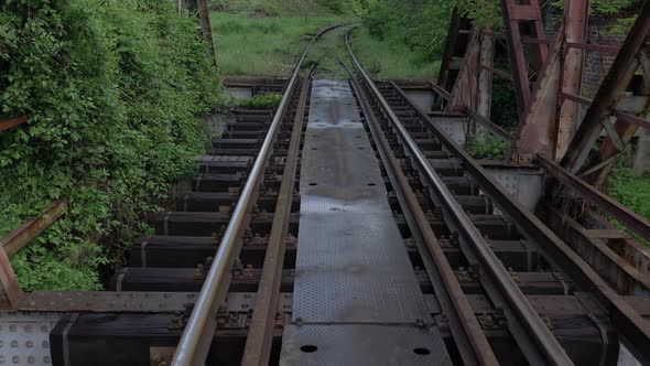 Backwards flying over the old style bridge with railway track 4K drone footage alt