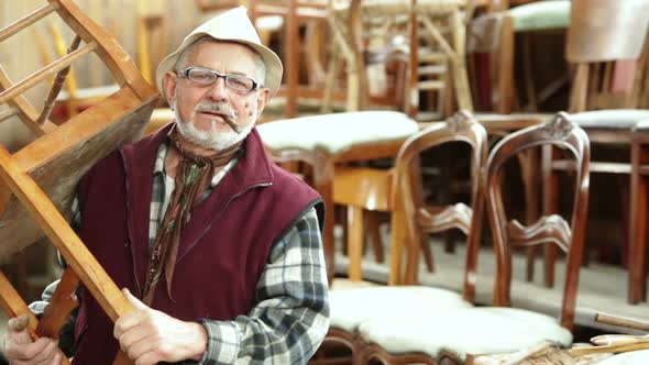 Senior Secondhand Dealer Smoking Cigar Portrait in His Shop