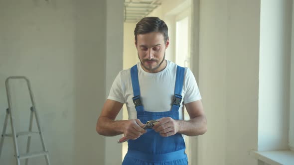 Builder Stands and Looks at the Instrument alt