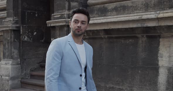 Young Man Travels Through The Ancient City In A Bright Suit alt