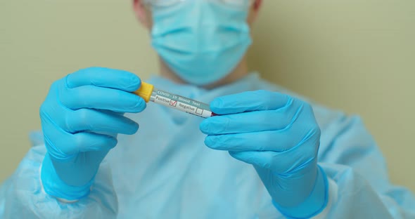 Doctor Showing Tube, Positive Result of Blood Test for Coronavirus, Covid-19. alt