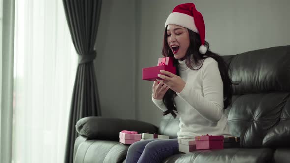surprise woman opening christmas gift in the living room