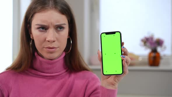 Closeup Chromakey Smartphone in Hand of Dissatisfied Young Woman Shaking Head alt