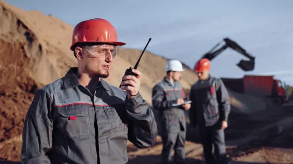 Male Industrial Engineer Talking Using Walkie Talkie at Construction Site Medium Shot alt