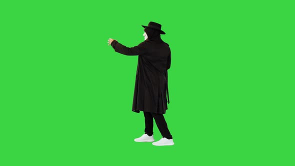 Performer Artist at Halloween Party Showing Tricks Magician Man in Black Clothes and White Mask on a
