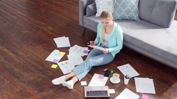 Young woman works with documents using a laptop at home. alt