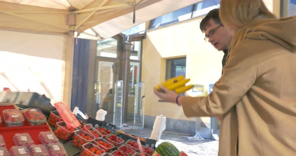 Man And Woman Choosing Ripe Bananas alt