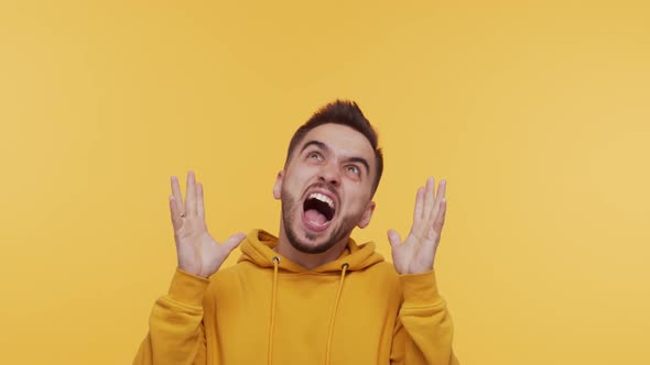 Expressive young man screaming and shouting over vibrant background. alt
