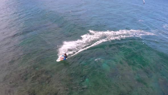 Aerial view of a man kitesurfing in Hawaii. alt