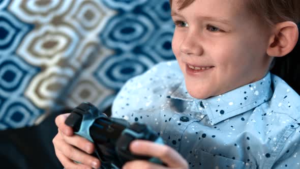Young Boy Plays Video Game with Joystick and Showing Lots of Emotions