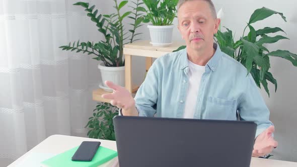 Male Blogger Sit at Desk in Front of Laptop Look at Pc Screen alt