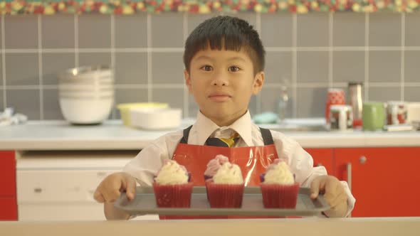 MS Portrait of schoolboy holding cupcake