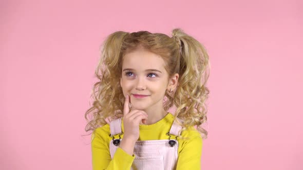 Pretty Blond Young Girl Is Thoughtful in Studio on Pink Background. Slow Motion alt