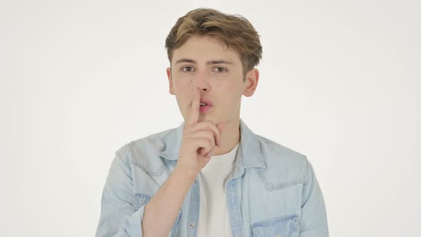 Young Man with Finger on Lips Silence Please alt