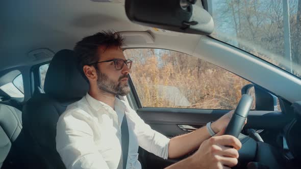 Man Sitting Relaxed In Newly Bought Car. Driver On Trip. Man Driving Car Enjoy Traveling Road. alt