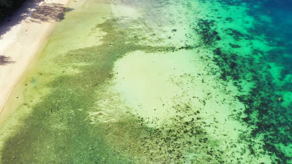 Sea texture with coral reefs growing under calm clear water of shallow lagoon near shore of tropical alt