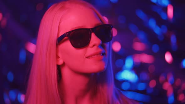 Fashionable Woman in Sunglasses is Dancing in a Nightclub