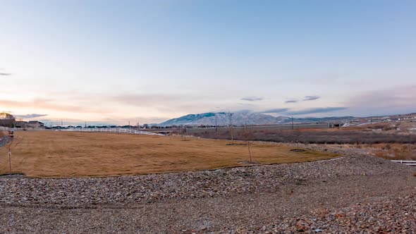 Morning dawns over a grassy field in a suburban neighborhood - colorful cloudscape time lapse alt