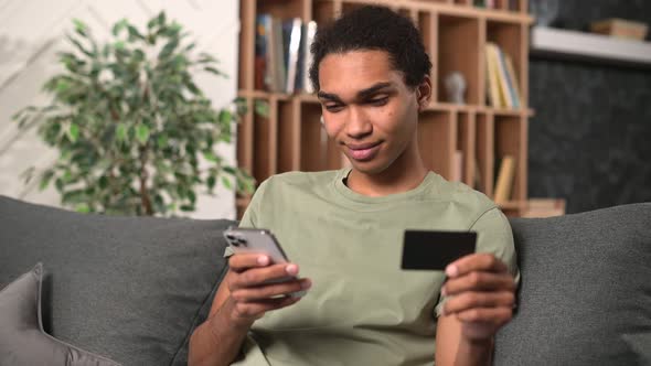 Young Handsome Freelancer Man Using Smartphone for Online Payment