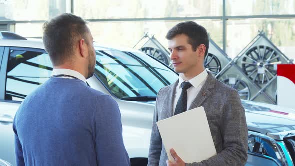 A Representative Seller Gives the Car Keys To the Buyer