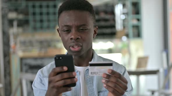 Portrait of Online Payment Failure on Phone By Young African Man alt